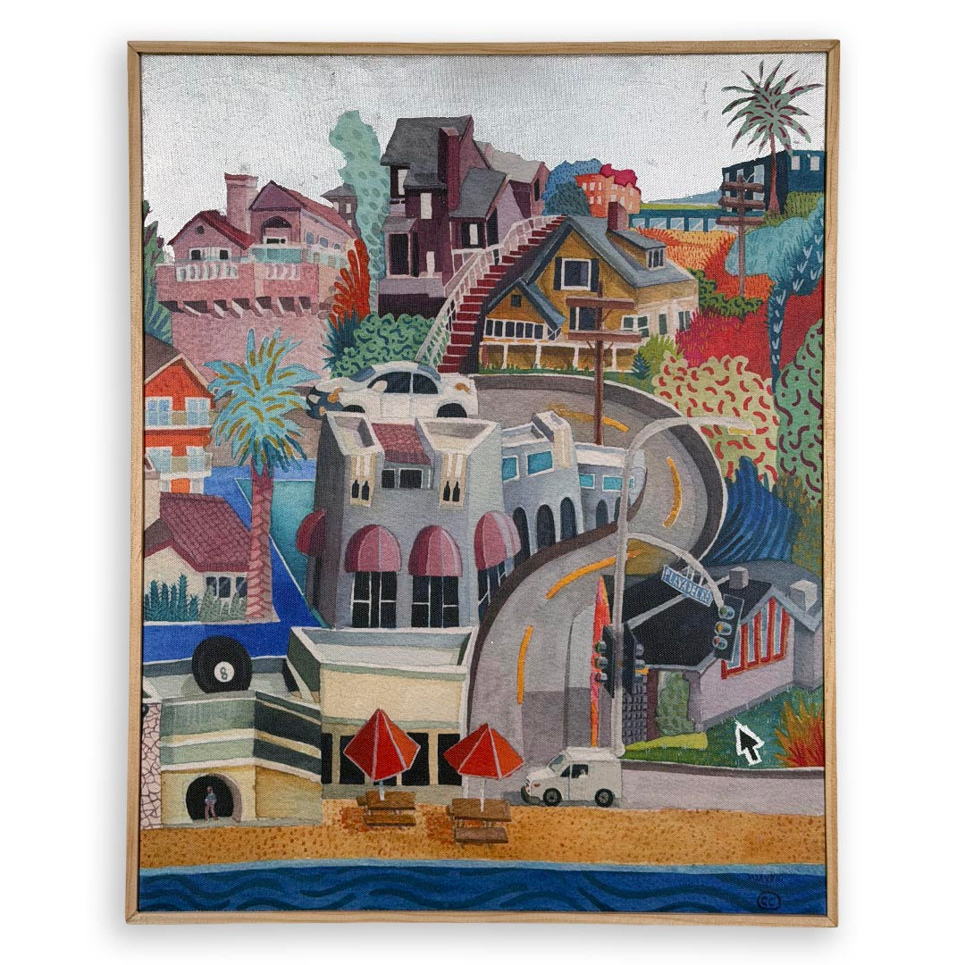A framed colorful painting depicting a coastal hillside town with houses, palm trees, a curved road, beach umbrellas, and blue ocean water at the bottom. White background, silver foil sky.